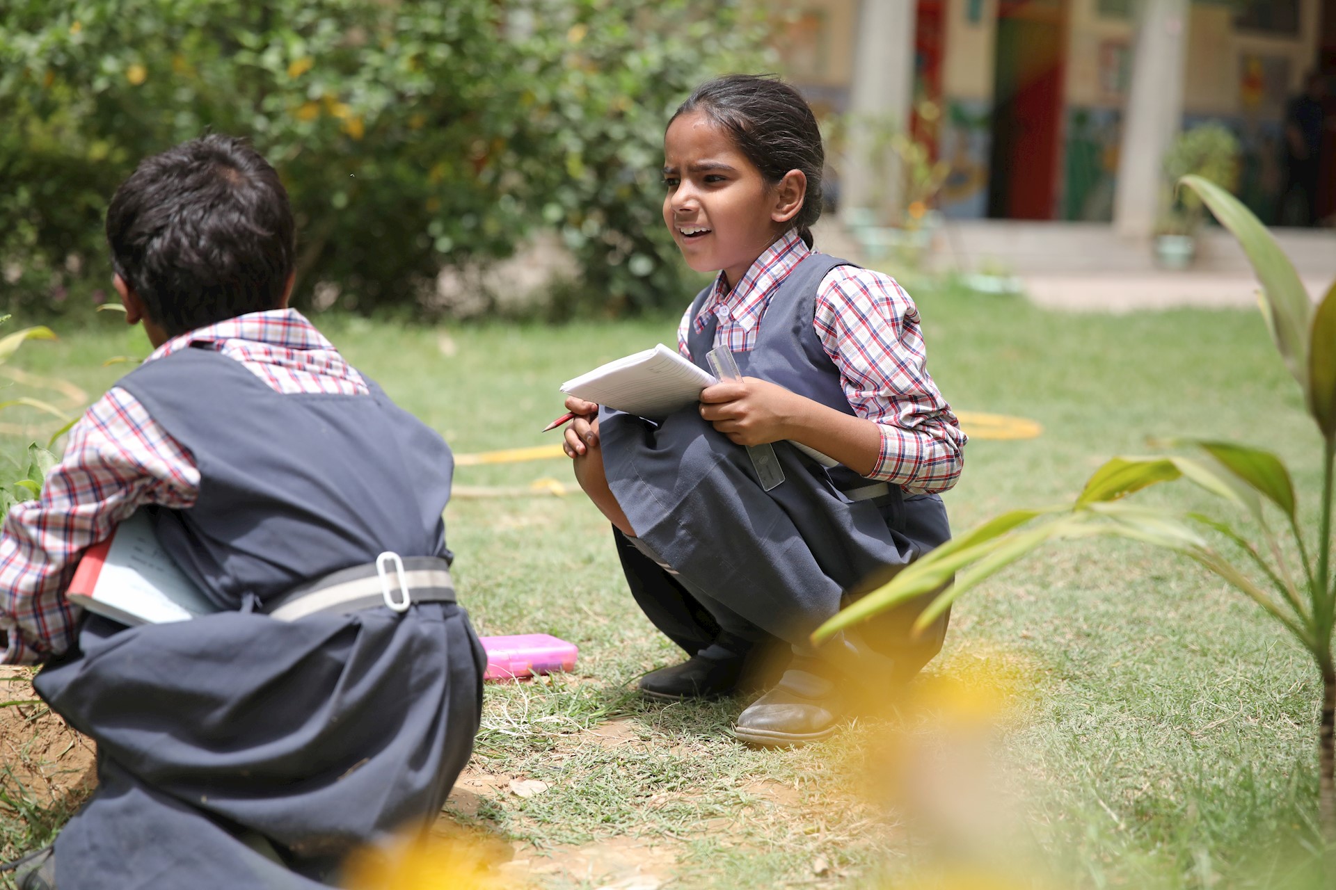two young girls learning outside, India 
