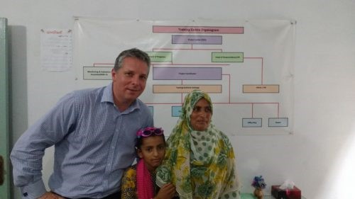 CEO poses with two women from projects