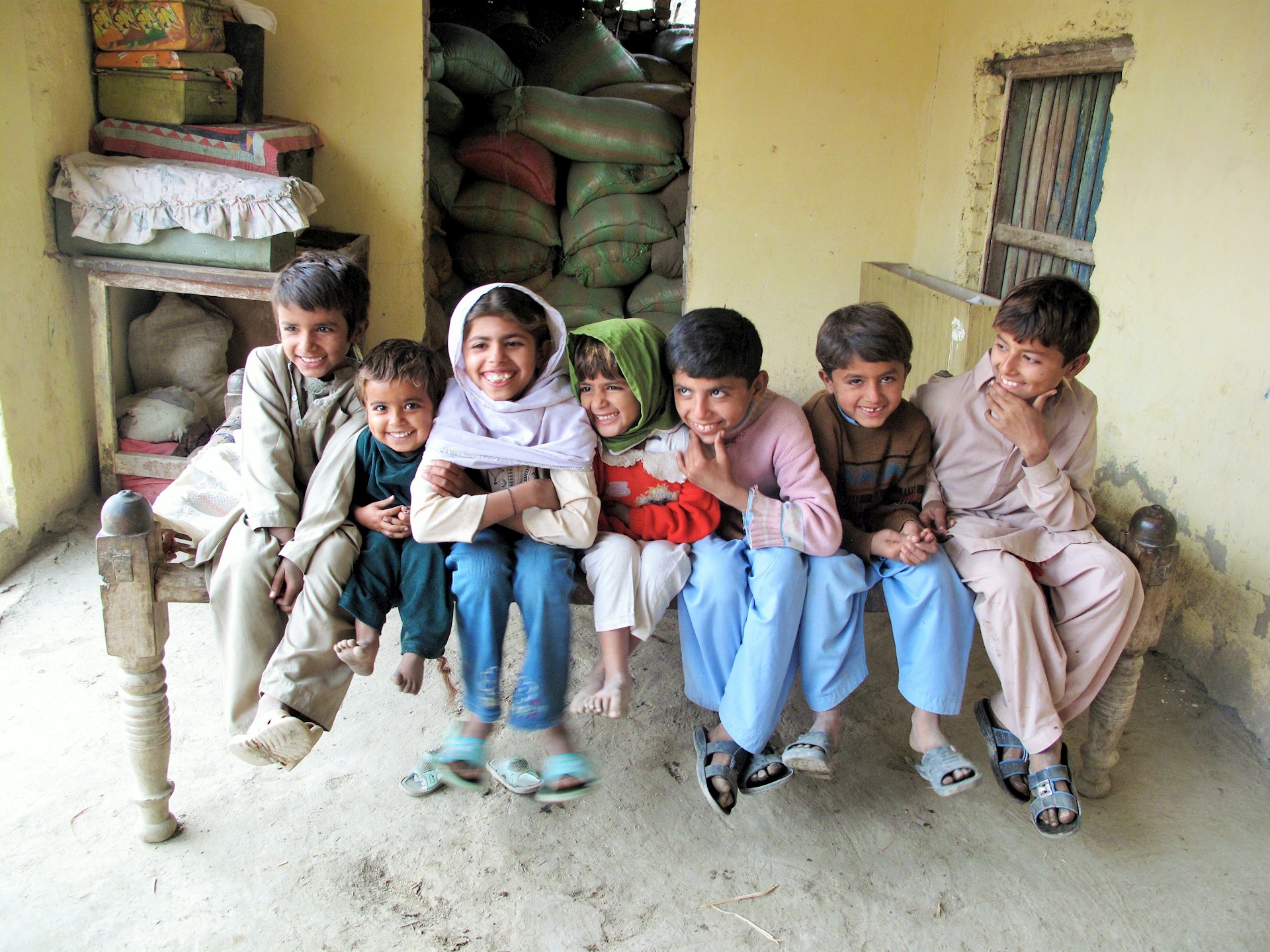children sat on a bed laughing 