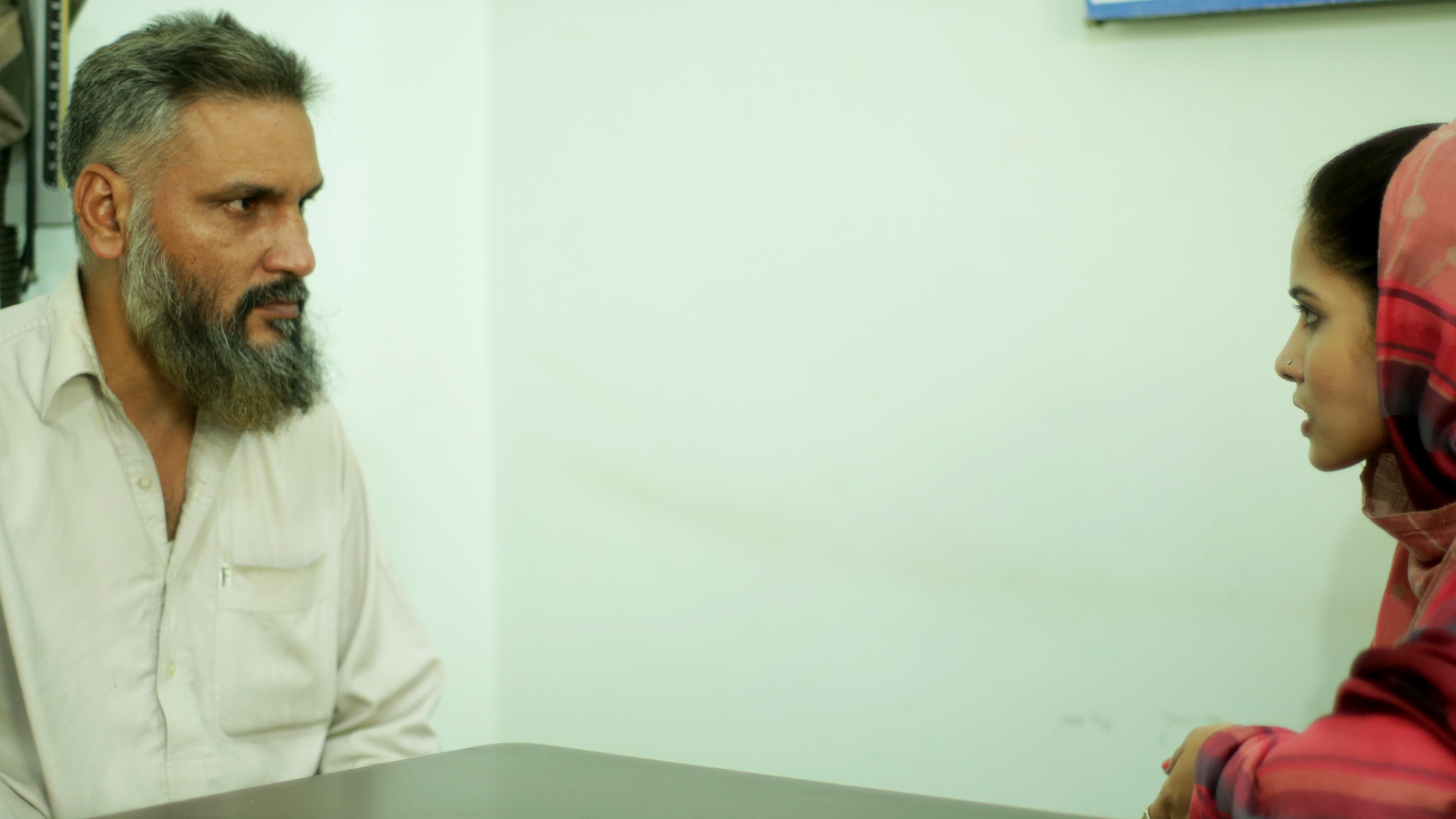 Adult man being interviewed in a room 