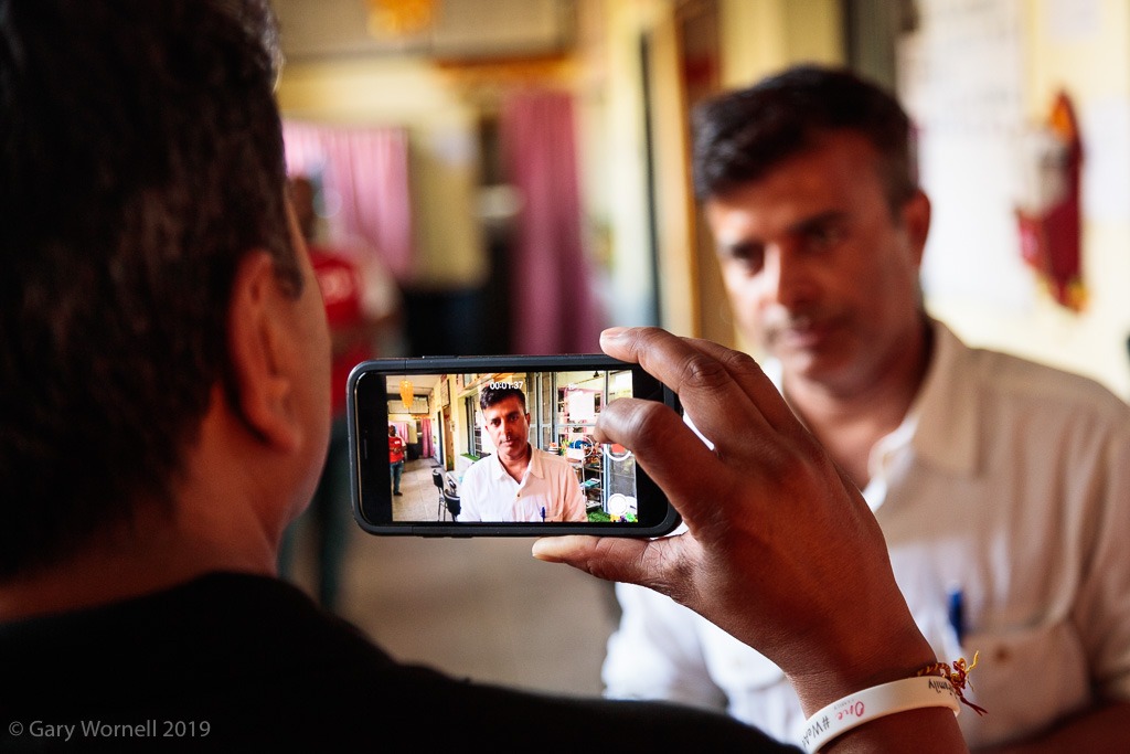 a man being photographed taking a photo of a man on his phone 