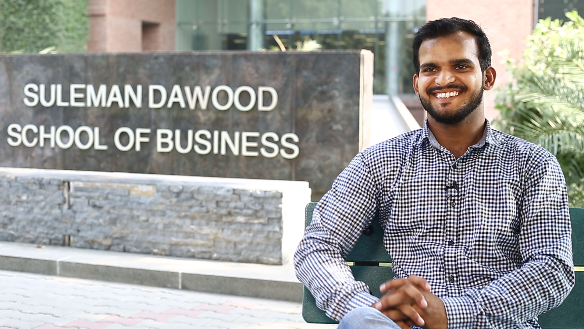 Young man in front of business school, Pakistan  