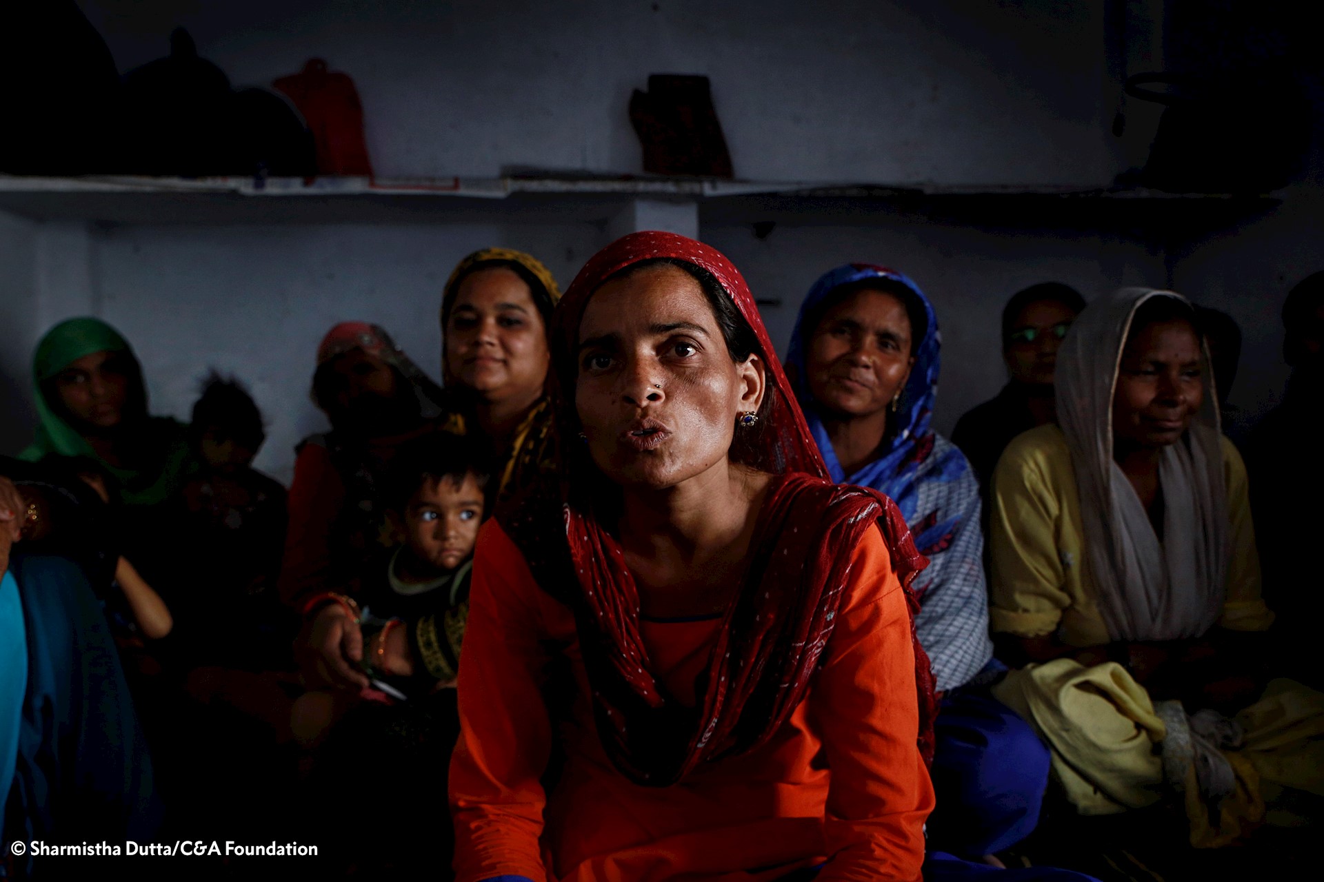 Women and children in dark room 