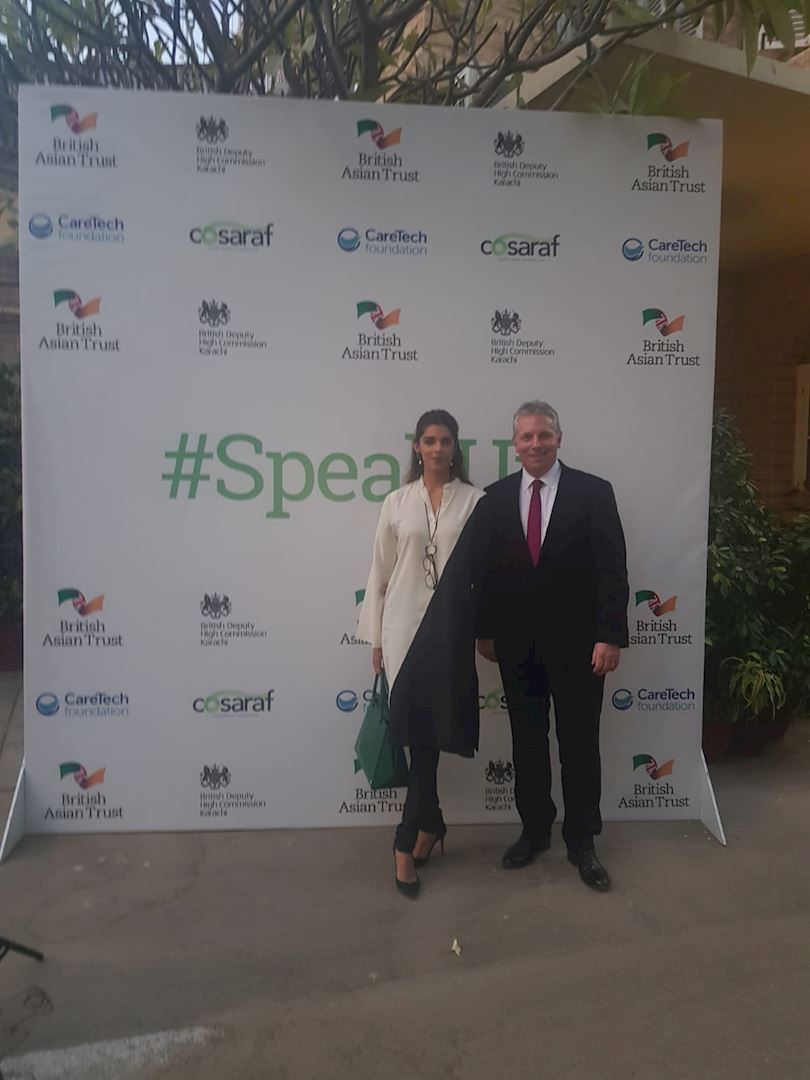 British Asian Trust CEO Richard Hawkes and Ambassador Sanam Saeed being photographed in front of media board 