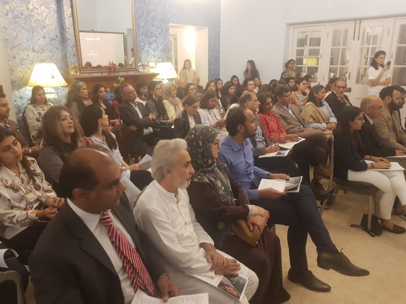 Room full of people and participants at mental health event in Pakistan